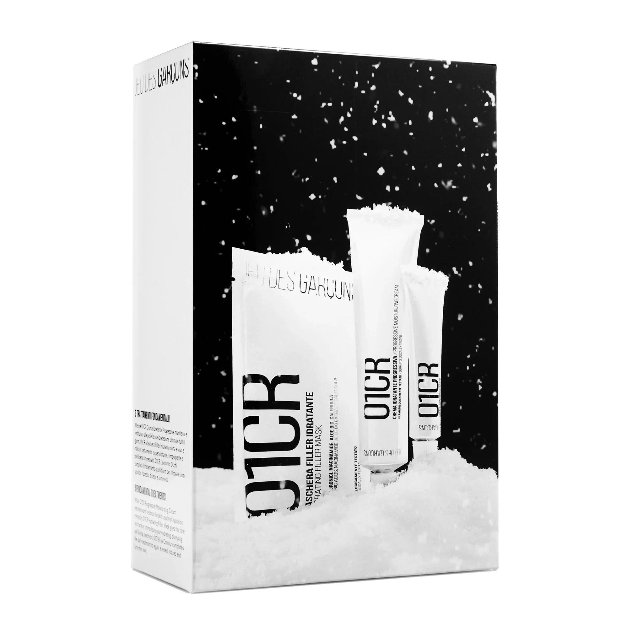 Cofanetto regalo skincare O1CR con maschera e creme idratanti su sfondo neve nera