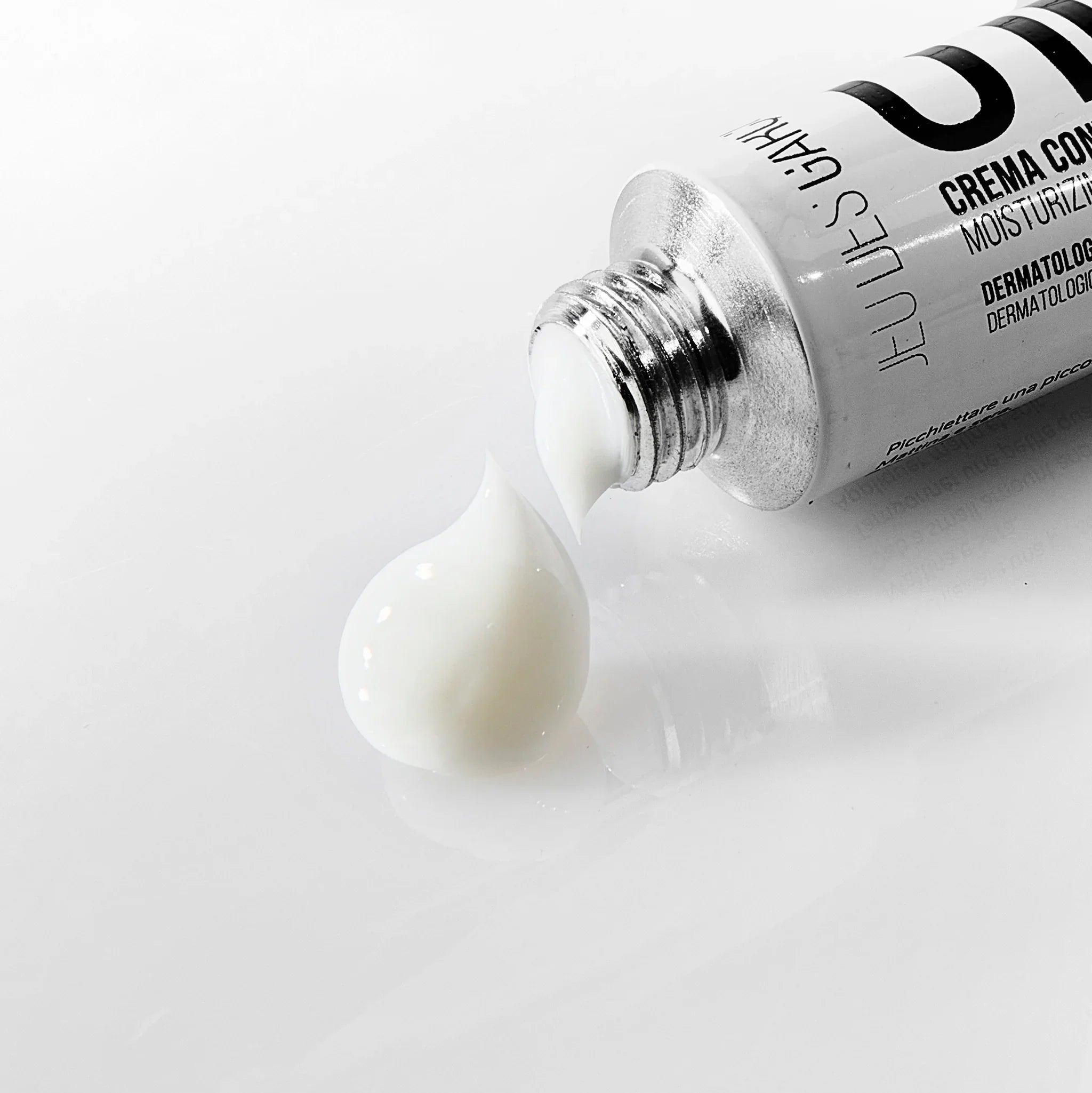 Tubo di crema contorno occhi bianca con texture morbida su superficie bianca lucida