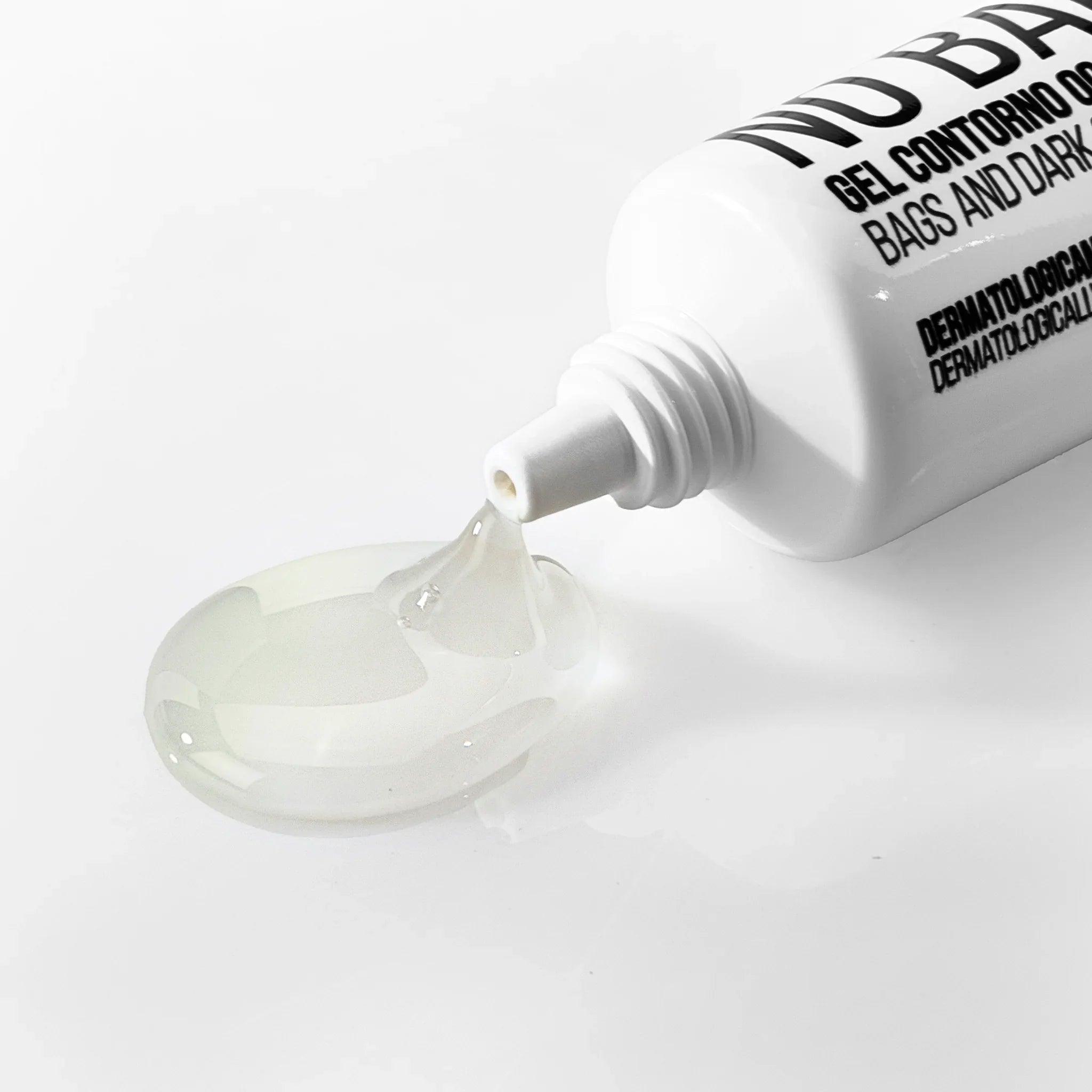 Gel contorno occhi anti borse e occhiaie trasparente versato da tubo bianco su superficie bianca