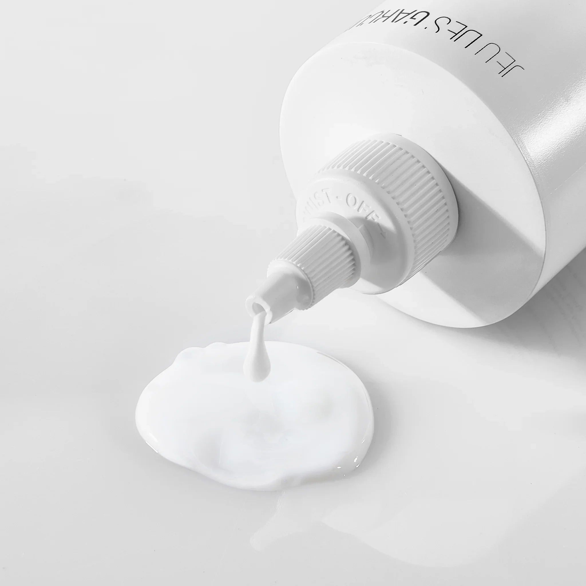 Detergente latte bianco che esce da tubo bianco su superficie lucida bianca