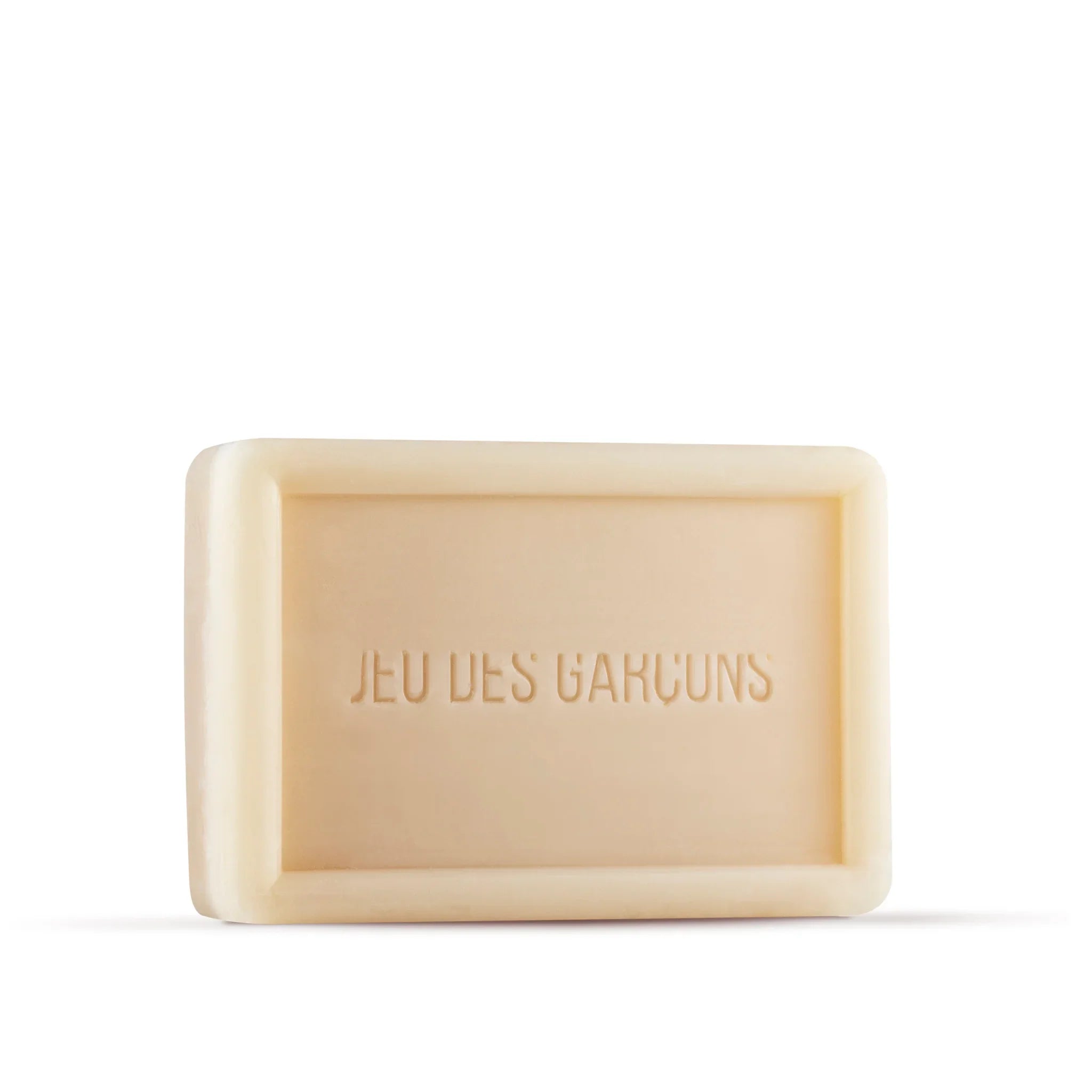 Sapone vegetale solido beige con scritta incisa 'Jeu des Garçons' su sfondo bianco